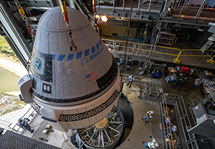 The Boeing CST-100 Starliner spacecraft is guided into position above a United Launch Alliance Atlas V rocket at the Vertical Integration Facility at Space Launch Complex 41 at Floridaâ s Cape Canaveral Air Force Station on Nov. 21, 2019. Starliner will be secured atop the rocket for Boeingâ s Orbital Flight Test to the International Space Station for NASAâ s Commercial Crew Program. The spacecraft rolled out from Boeingâ s Commercial Crew and Cargo Processing Facility at NASAâ s Kennedy Space Center earlier in the day.